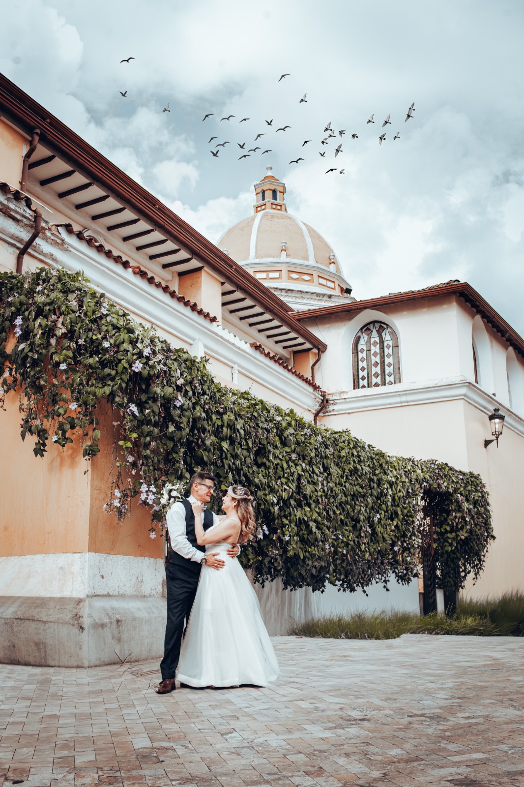 Pareja junto a iglesia con pájaros